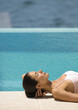 Woman lying on ground near edge of pool