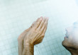 Man in shower with hands up