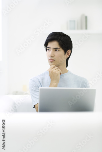 Photo: Man holding chin and looking away Man holding chin and looking away