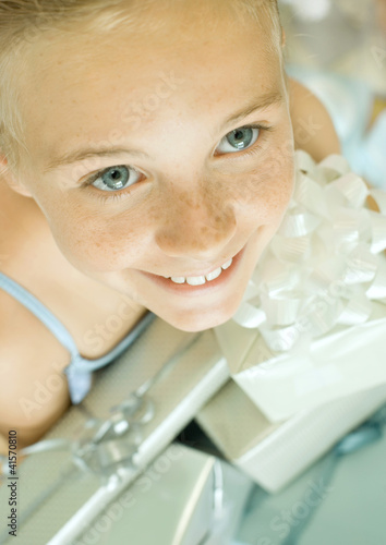 Photo: Girl holding armful of presents, high angle view Girl holding armful of presents, high angle view