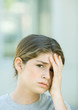 Preteen girl holding head