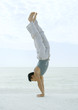 Man doing handstand on beach