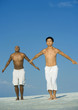 Photo: Two men doing relaxation exercises on the beach Two men doing relaxation exercises on the beach