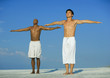 Photo: Two men doing relaxation exercises on the beach Two men doing relaxation exercises on the beach