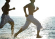 Two men running on beach
