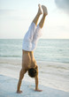 Man doing handstand on beach
