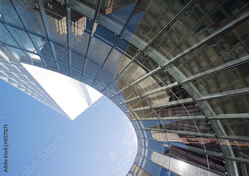 Photo: Skyscraper with reflection of buildings on facade, low angle, abstract view Skyscraper with reflection of buildings on facade, low angle, abstract view