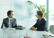 Two businessmen sitting at table, having meeting