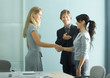 Businessman introducing teenage girl to young professional woman
