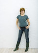 Young woman standing with hands in pockets, full length portrait