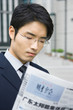 Businessman reading Chinese newspaper