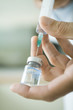 Doctor filling syringe from bottle