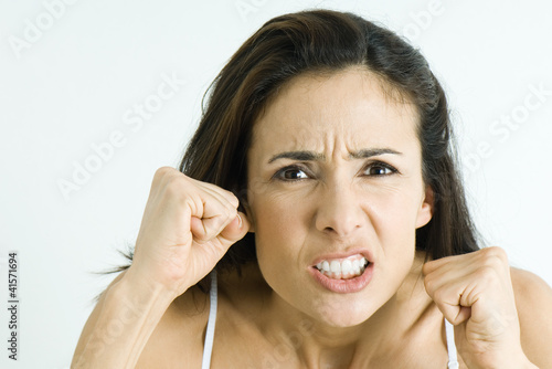 Foto: Woman making angry face, holding up fists, portrait Woman making angry face, holding up fists, portrait