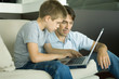Father and son using laptop together
