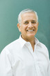 Mature businessman smiling at camera, portrait, close-up