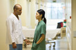 Medical staff standing face to face in hospital corridor, discussing