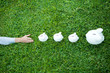 Man reaching for line of piggy banks, cropped view