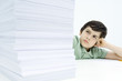 Boy looking at tall stack of homework, frowning