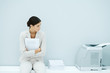 Photo: Young woman in suit sitting next to printer Young woman in suit sitting next to printer
