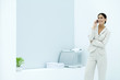 Young businesswoman using cell phone in office, smiling