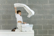 Little boy playing with laundry, smiling, side view