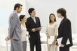 Group of business associates standing together, smiling, chatting