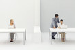 Two women working in office, man standing behind one with his hand on her shoulder