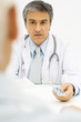 Doctor giving patient prescription drugs, over the shoulder view, cropped