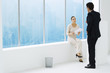 Two business associates by window, having conversation