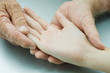 Man holding young person's hand, palm facing up, cropped view
