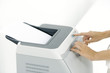 Photo: Hands pushing button on printer, cropped view Hands pushing button on printer, cropped view