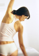 Photo: Woman standing in underwear, stretching, rear view Woman standing in underwear, stretching, rear view