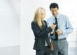 Businesswoman showing businessman cell phone
