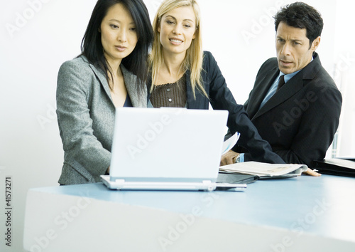 Photo: Businesspeople working on laptop together Businesspeople working on laptop together