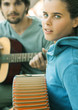 Young woman playing accordian and young man playing guitar