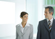 Businessman and businesswoman smiling at each other
