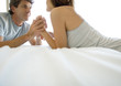 Couple lying on bed, holding hands