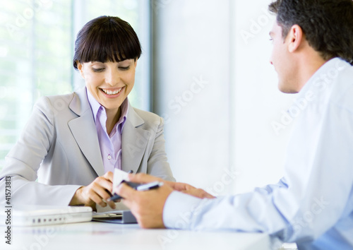 Photo: Man and woman having discussion in office Man and woman having discussion in office