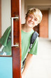cute high school boy behind classroom door