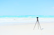 Digital Camera and tripod on white beach for landscape photograp Digital Camera and tripod on white beach for landscape photograp