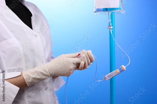 Photo: Nurse doing infusion on blue background Nurse doing infusion on blue background