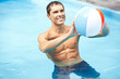 Mann mit Wasserball im Pool