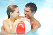 Paar im Pool mit Wasserball