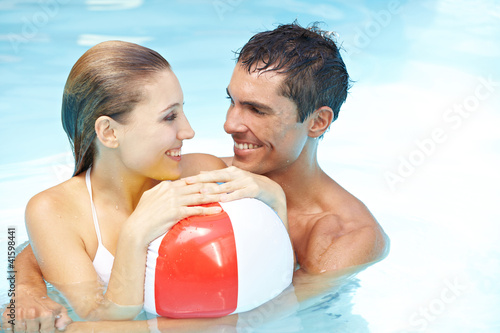 Photo: Paar im Pool mit Wasserball Paar im Pool mit Wasserball