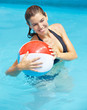 Frau mit Wasserball im Pool