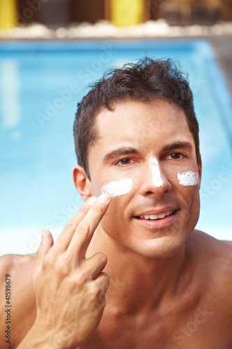 Photo: Mann cremt sein Gesicht ein Mann cremt sein Gesicht ein
