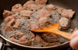 cooking meat in a frying pan