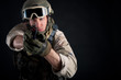 Soldier with gun against black background.