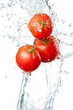 Three Fresh red Tomatoes in splash of water Isolated on white ba