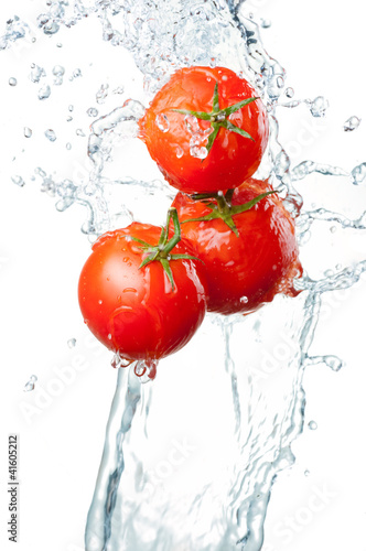 Photo: Three Fresh red Tomatoes in splash of water Isolated on white ba Three Fresh red Tomatoes in splash of water Isolated on white ba